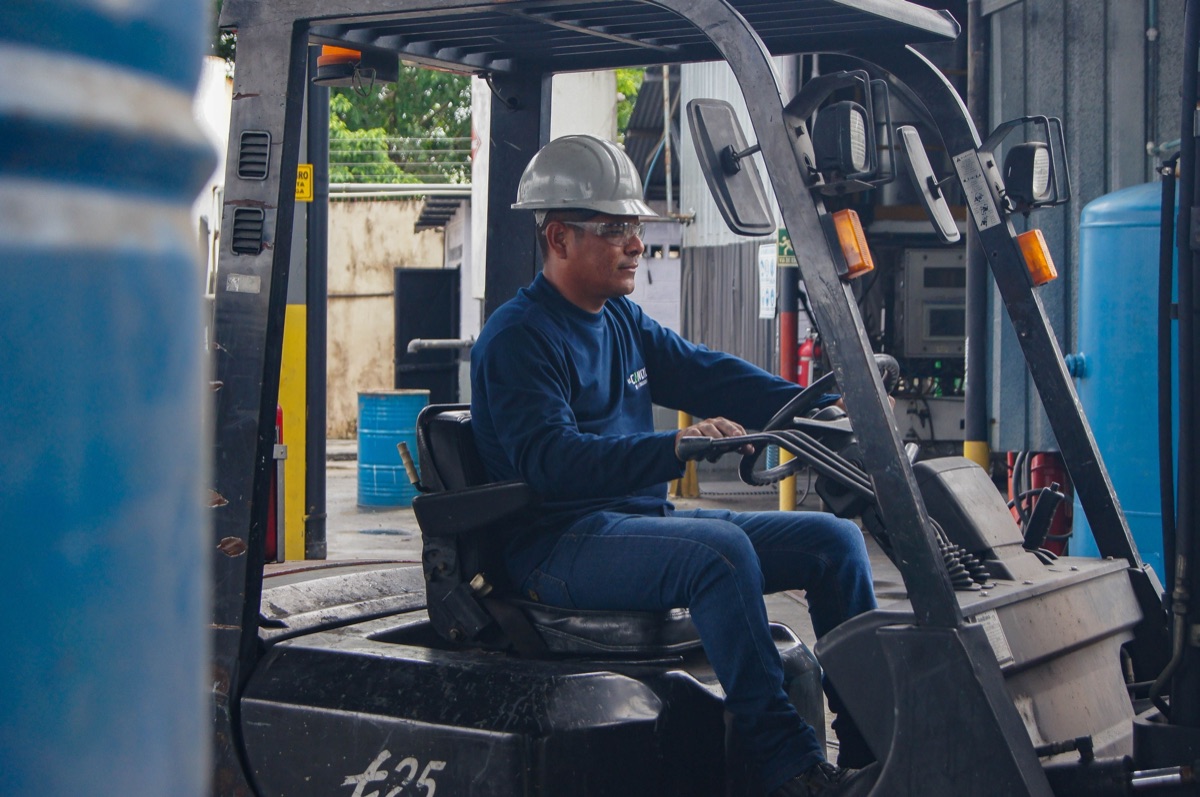 A Regal associate operating a forklift in a warehouse
